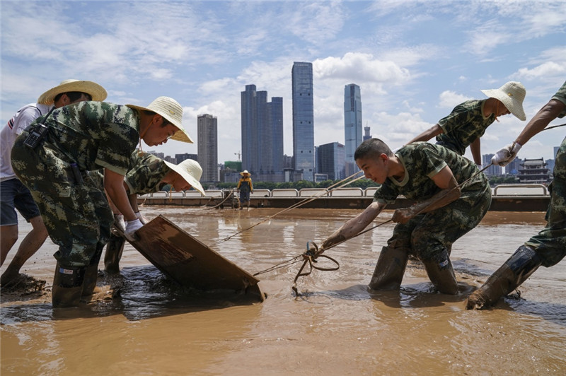 7月7日，武警官兵和工作人员在长沙橘子洲景区内清淤。