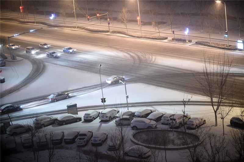 2月20日，在银川市街头，车辆在雪中行进。