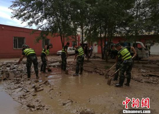 图为边防官兵为百姓清理淤泥。　贾天娇 摄